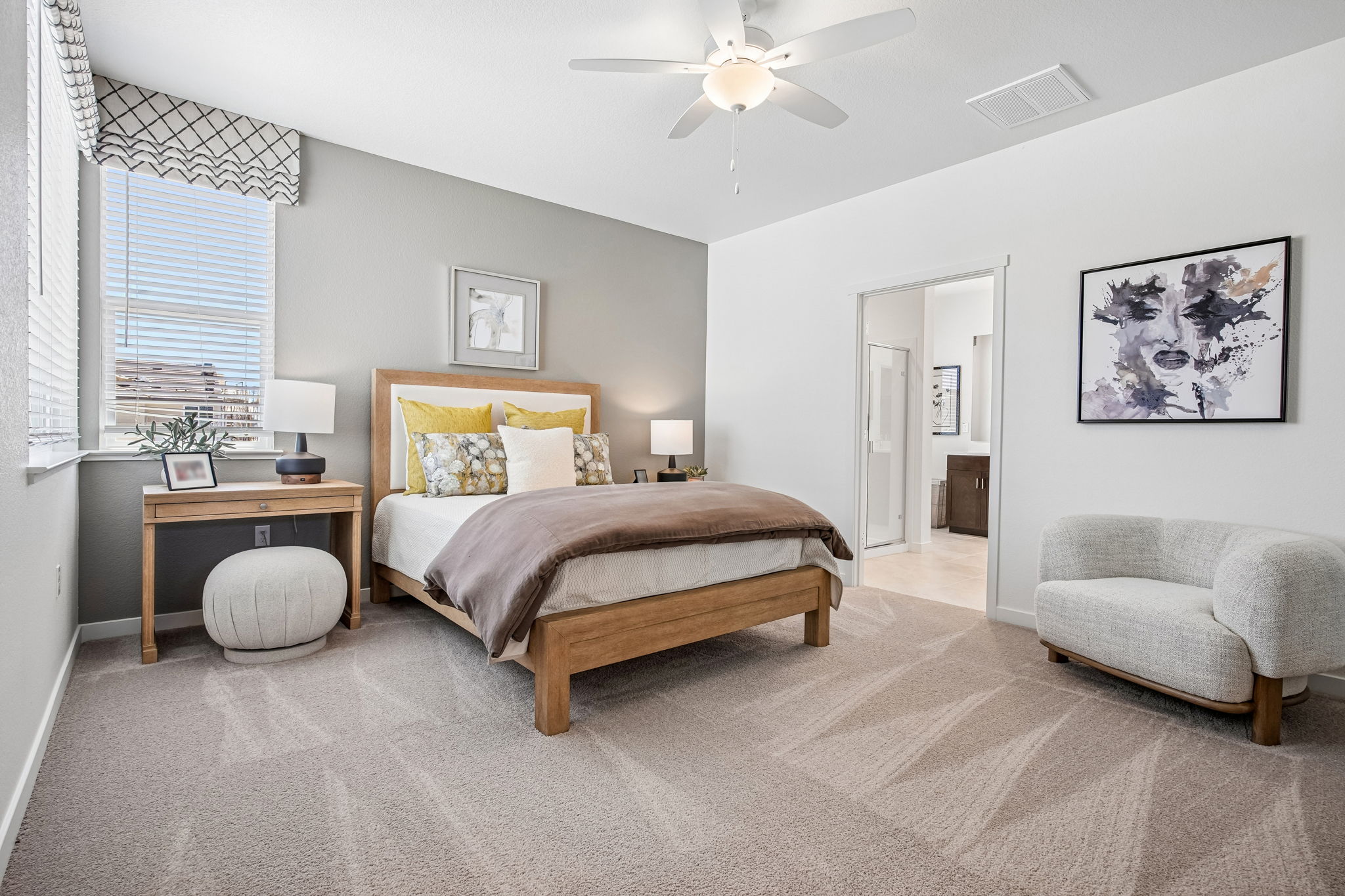 Bedroom with bed, chair, and view into bathroom