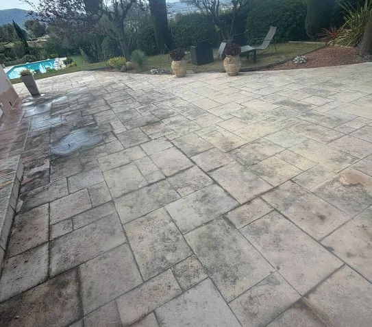 Piscine rectangulaire entourée d'une terrasse en bois avec mobilier de jardin et végétation luxuriante.