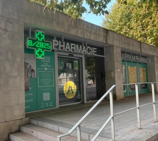 Façade extérieure d'une maison avec volets blancs ouverts, un mur en béton et des arbres verts sous un ciel bleu clair.