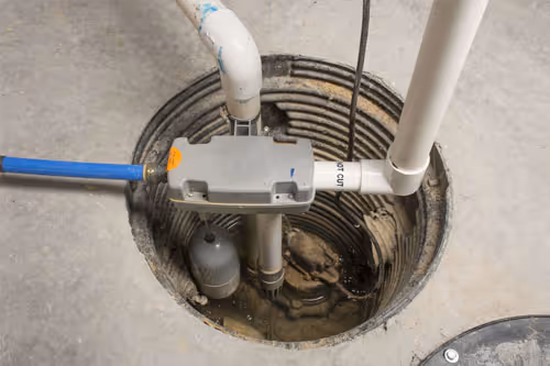 Sump pump installed in a circular pit with surrounding concrete floor.