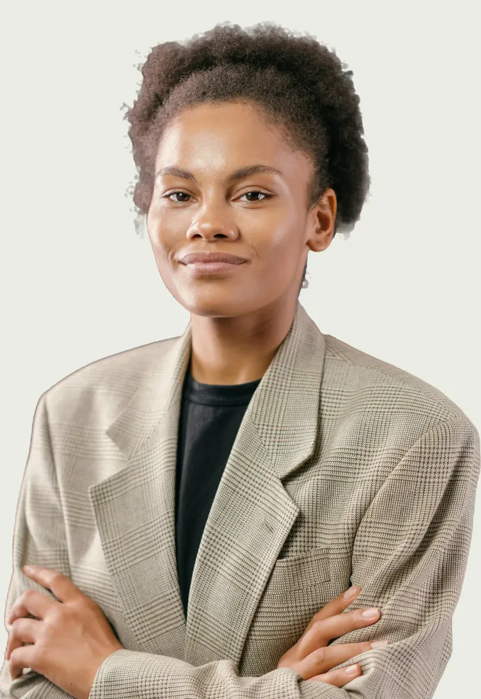Confident young woman with natural curly hair wearing a plaid blazer and black shirt, arms crossed.