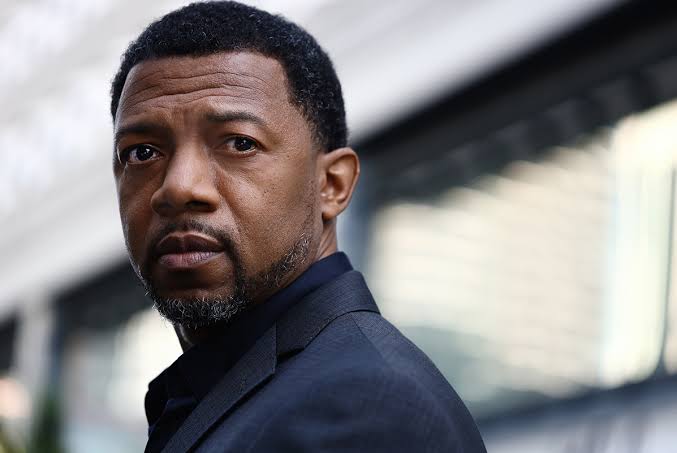 Serious mature man in black coat looking off-camera with contemplative expression