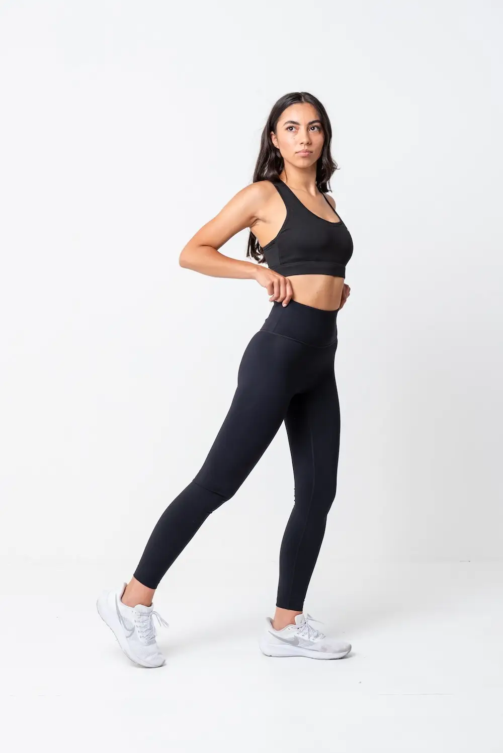Full-length ecommerce shot of a model in activewear on a clean white backdrop, lit with strobes at Bohemia Bay Studio