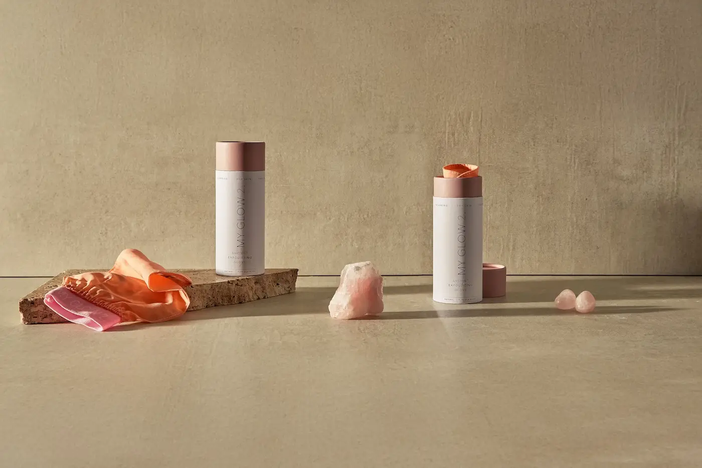Black metal rolling cart with two shelves and a light-colored top on a concrete floor against a gray concrete wall and white platform.