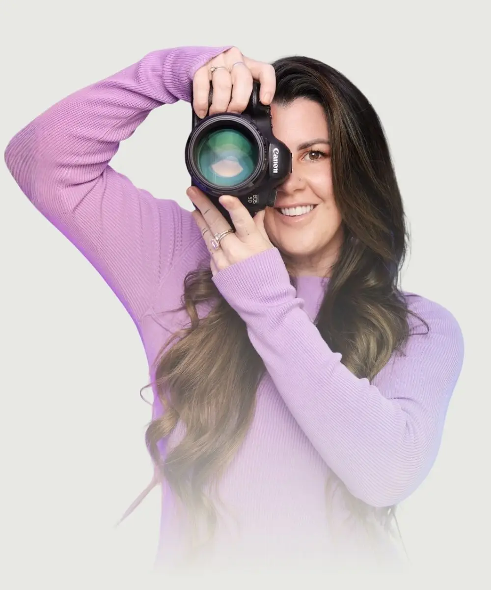 Black metal rolling cart with two shelves and a light-colored top on a concrete floor against a gray concrete wall and white platform.