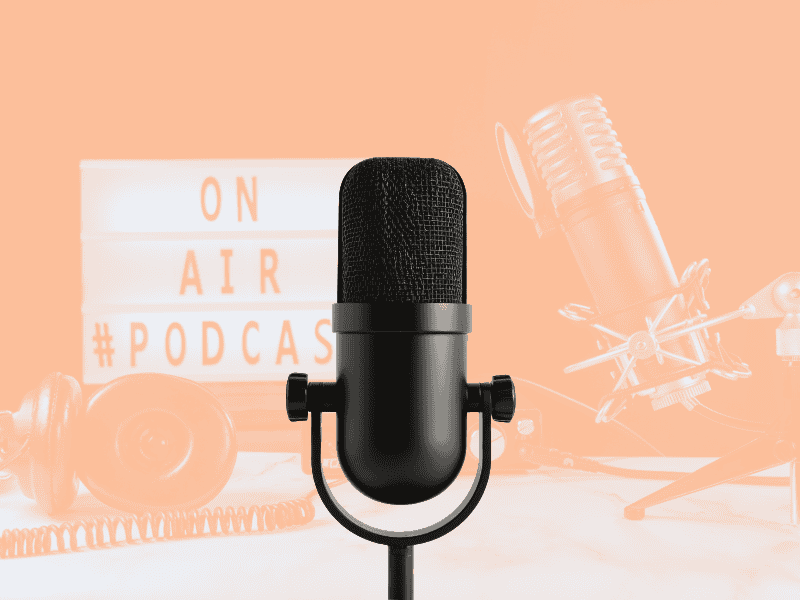 Svart mikrofon med budskapet «ON AIR #PODCAST» og headsett i bakgrunnen.