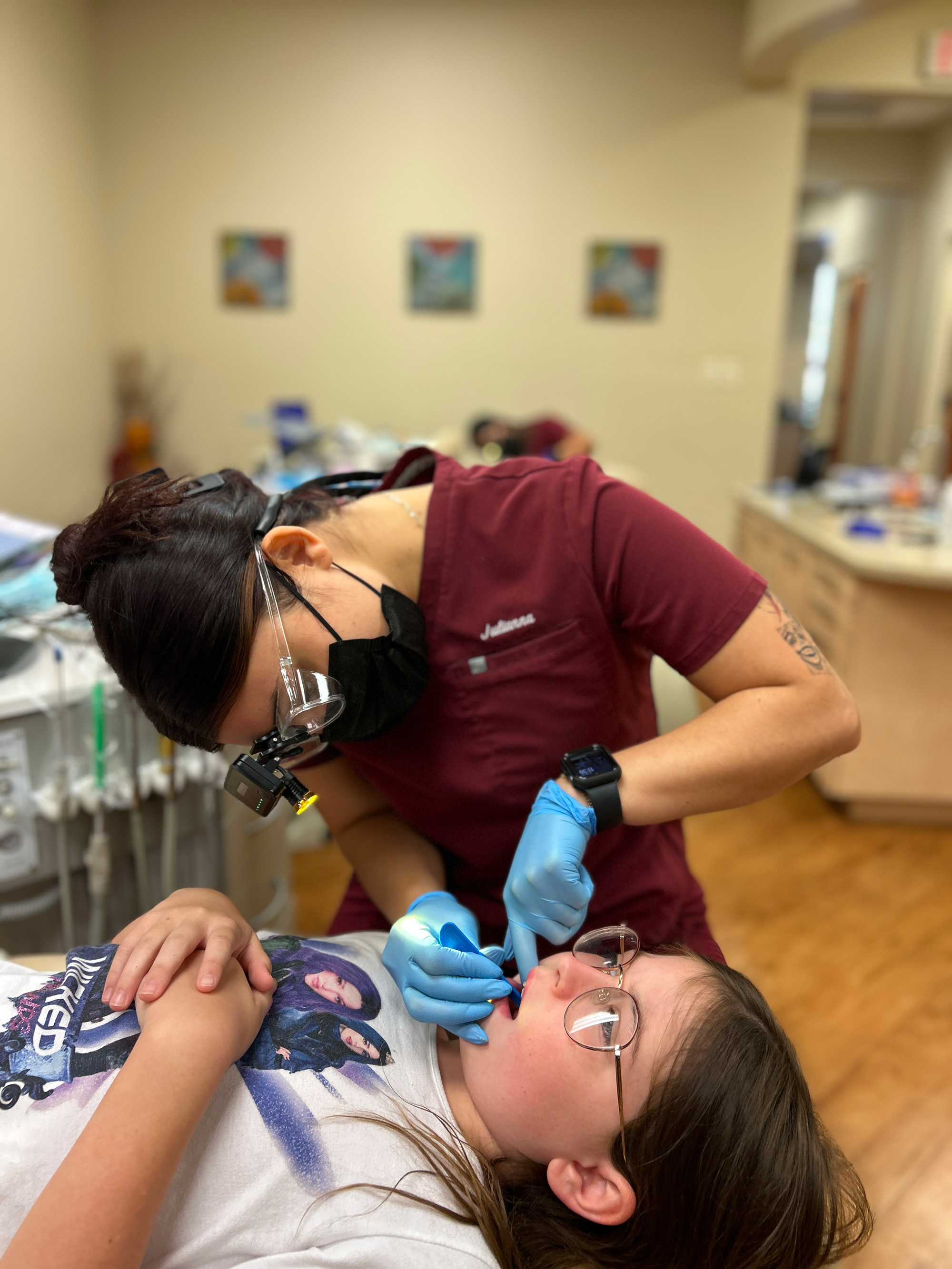 Ogden Orthodontics team member examining a young patient during an early orthodontic checkup