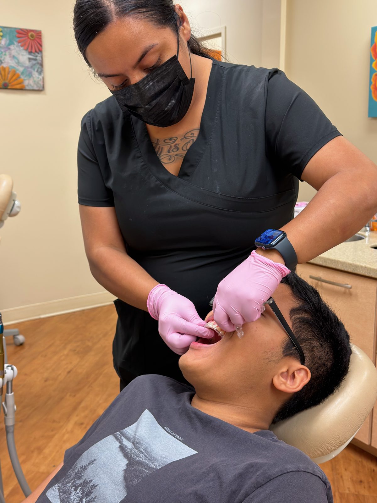 Team member seating a clear aligner for a teenage Invisalign patient at Ogden Orthodontics