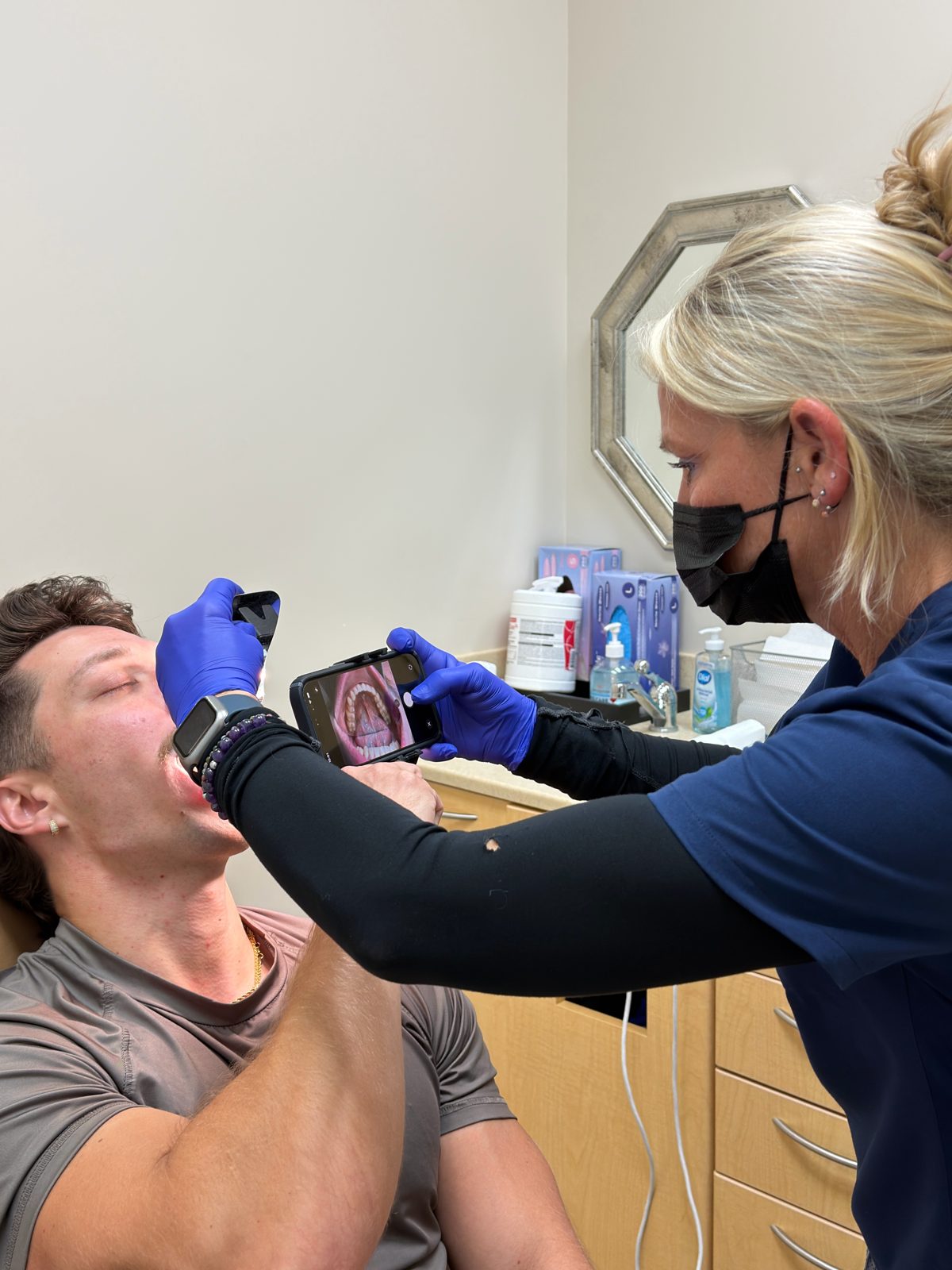 Team member taking intraoral photographs of a new patient at an Invisalign consultation at Ogden Orthodontics