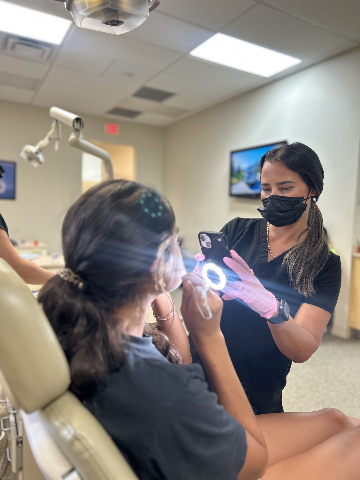 Orthodontic assistant taking intraoral photos of a patient during a records appointment at Ogden Orthodontics