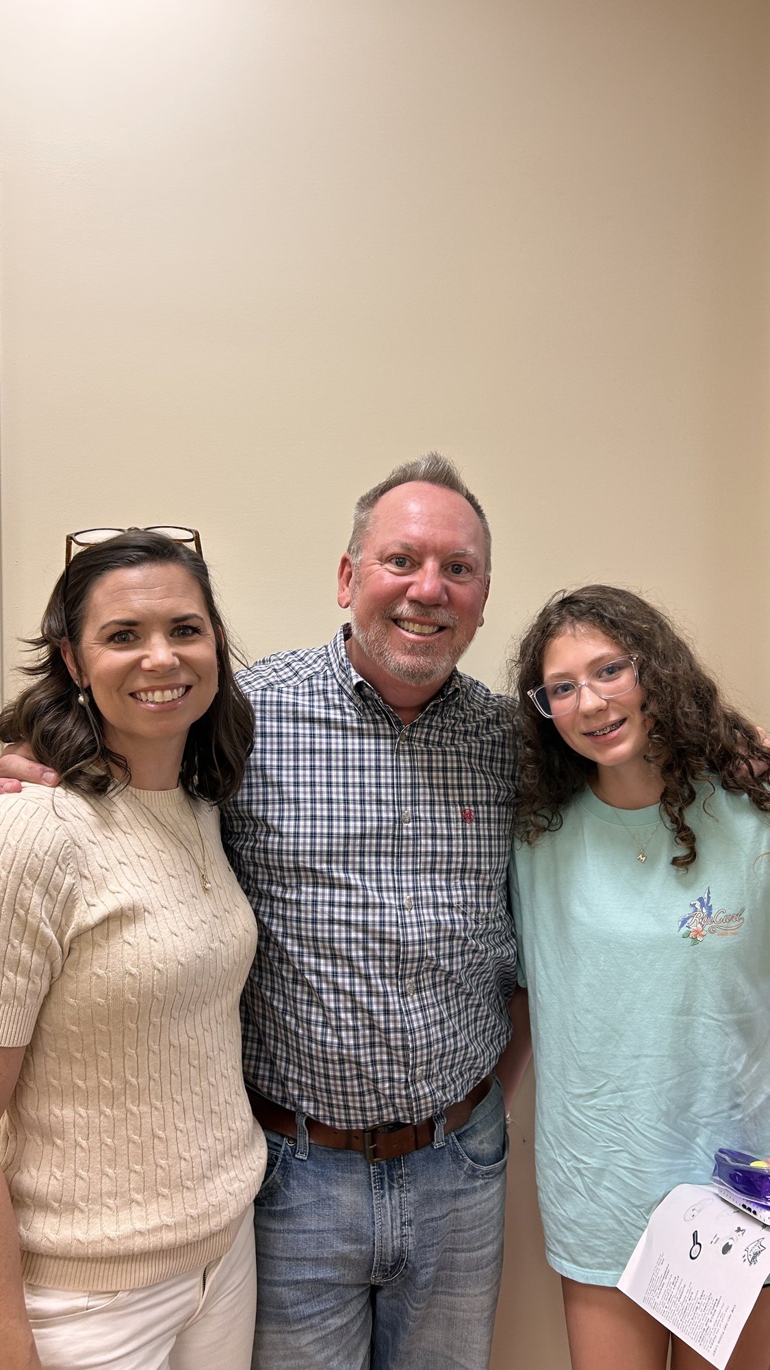 A teen patient with braces standing with a parent and Dr. Robert Ogden after an appointment