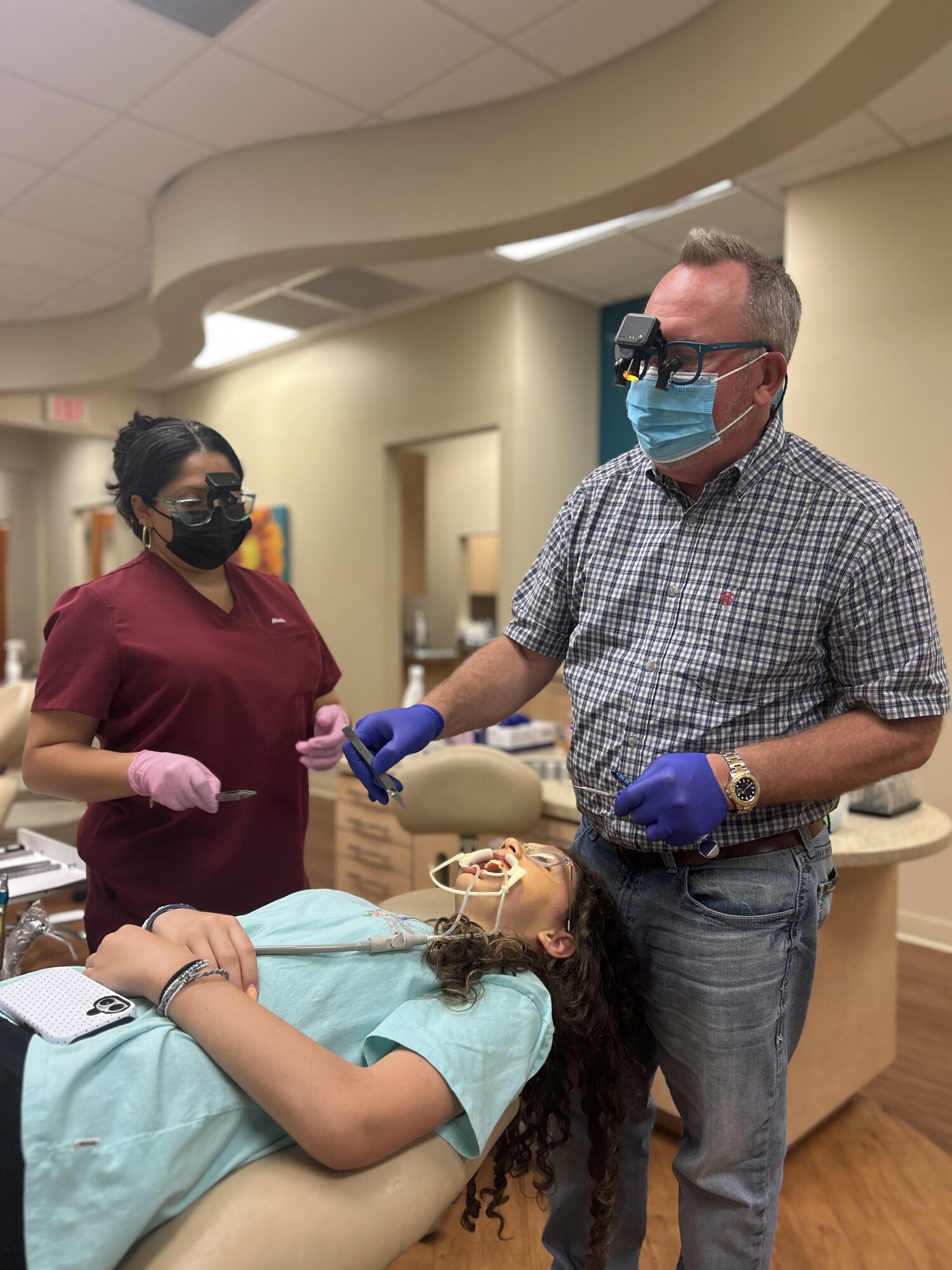 Dr. Robert Ogden and an assistant placing braces for a teenage patient at Ogden Orthodontics