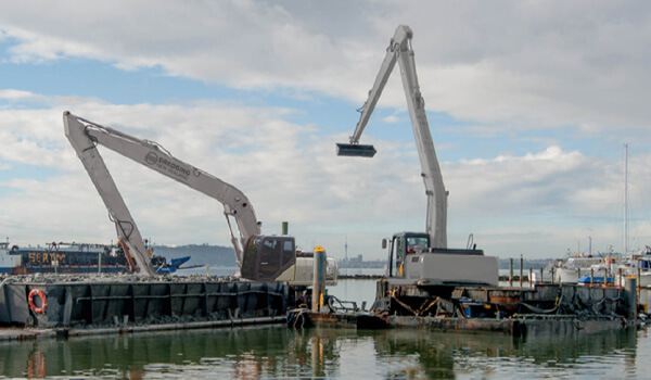 A spud hopper barge with a long-reach excavator