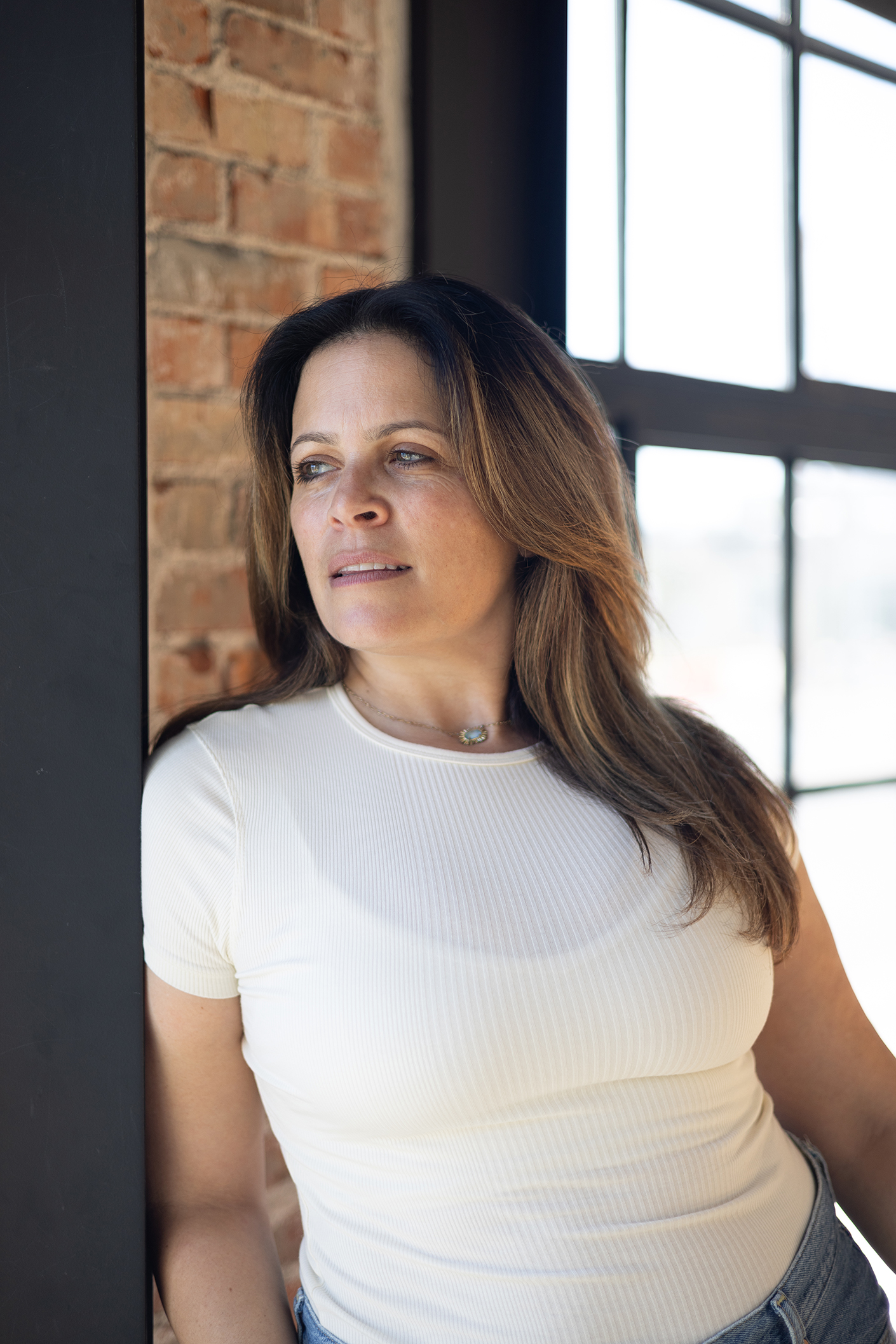 Melissa Silverstein standing by a window in a professional workspace