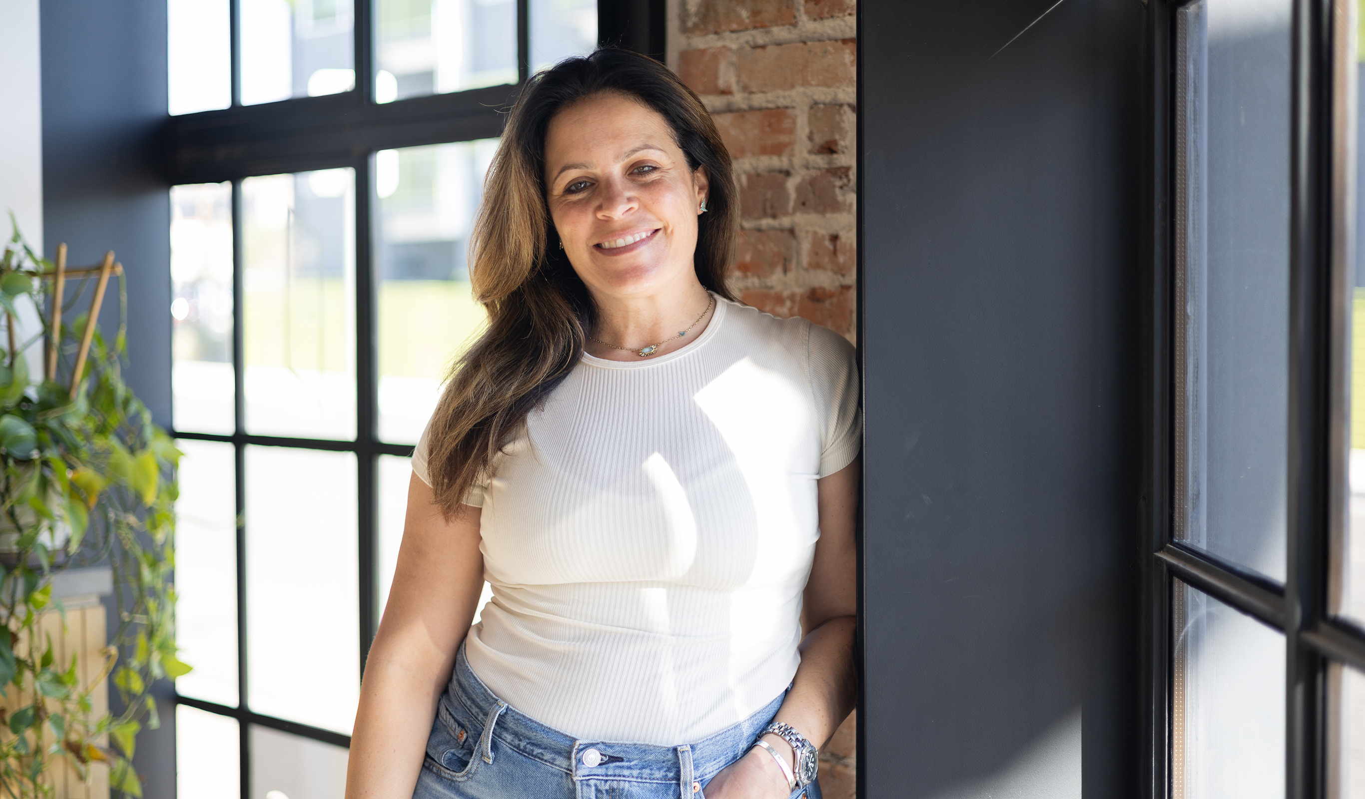Melissa Silverstein standing by a window in a professional workspace
