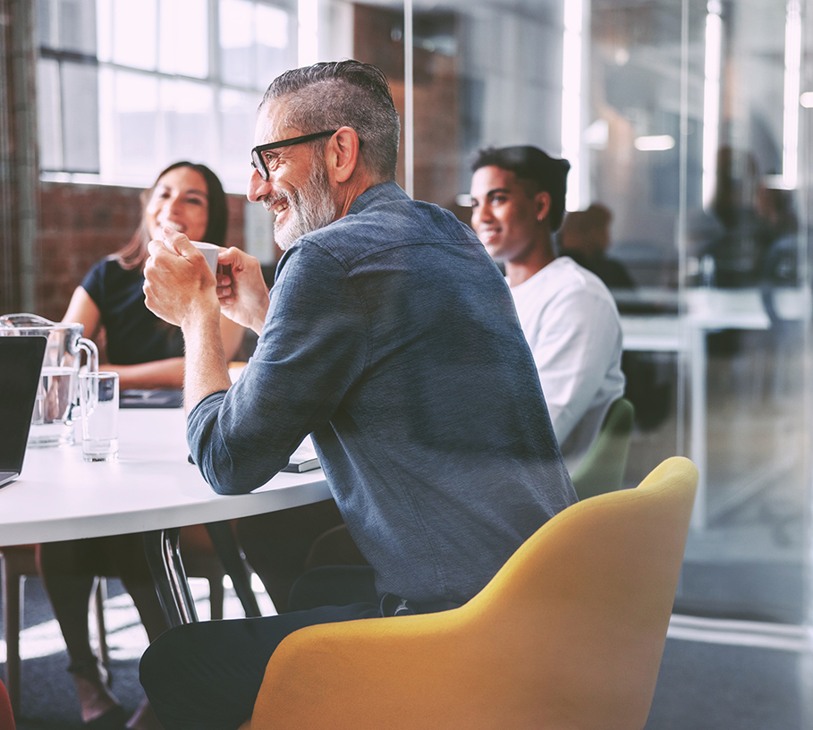 Group of professionals seated at a conference table during a workplace discussion