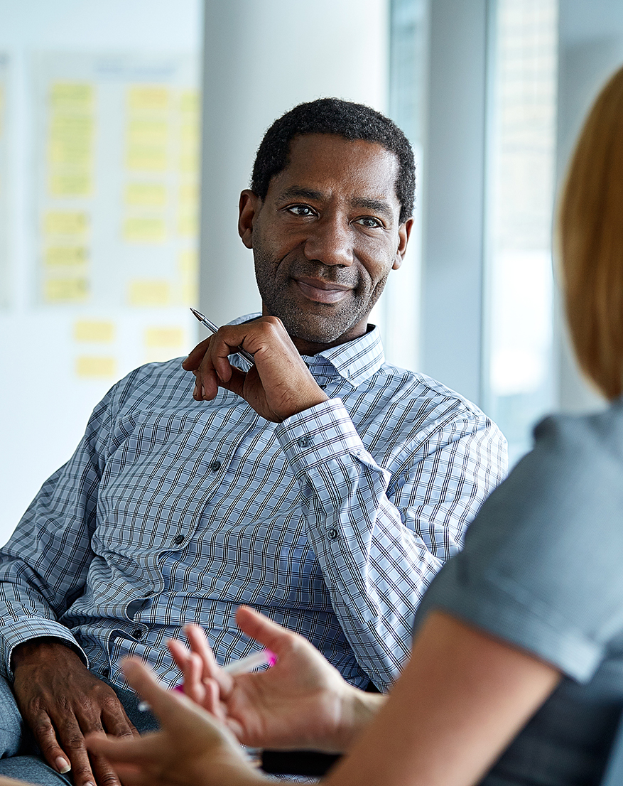 Two professionals in conversation during a workplace coaching or training discussion
