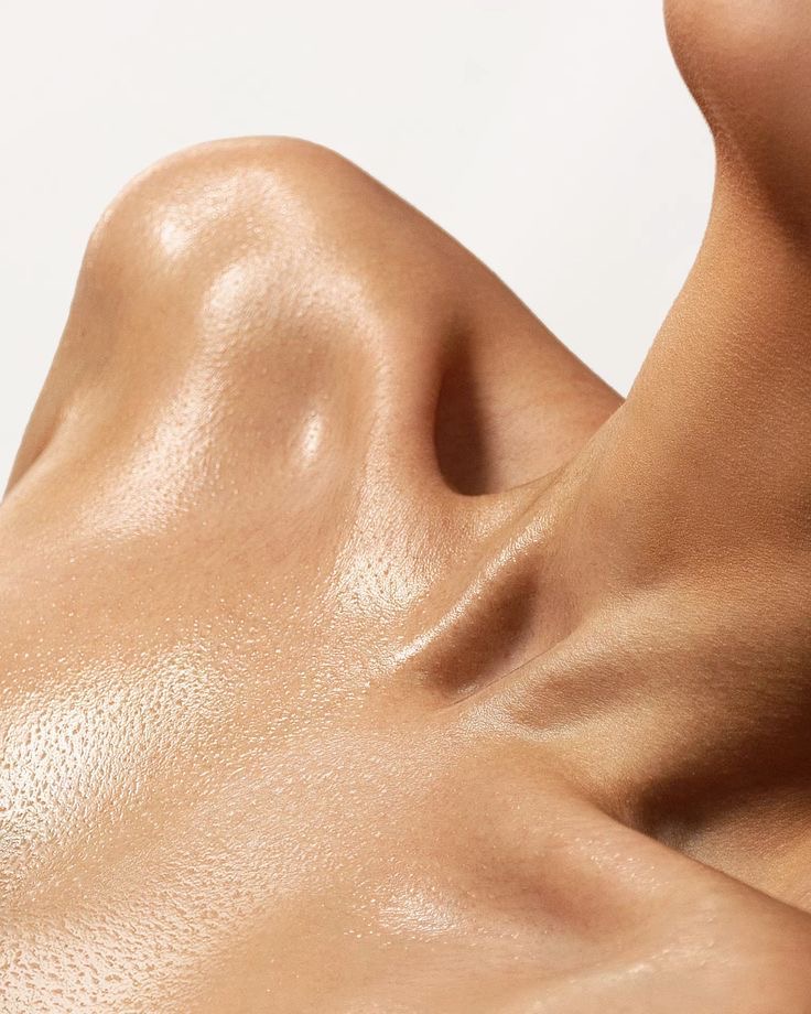 Close-up of a smooth, glowing shoulder and collarbone area on tanned skin posing for TANNED TO - an automated spray tan studio in Toronto.