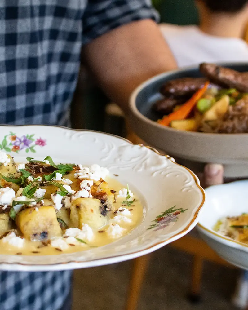 Une personne tenant une assiette décorée avec un plat d'origine marocaine