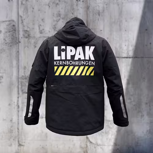 Schwarze Arbeitsjacke mit LIPAK Kernbohrungen-Logo auf dem Rücken. Gestaltet von WERKSCHWABEN.