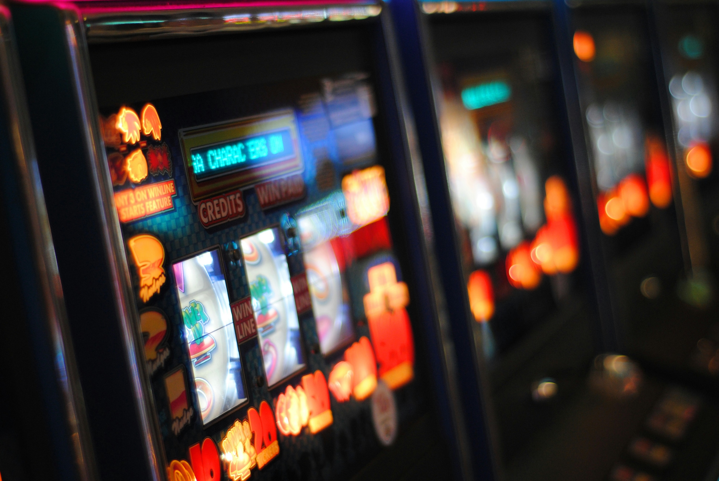 Illuminated poker machines arranged in a row with shallow depth of field