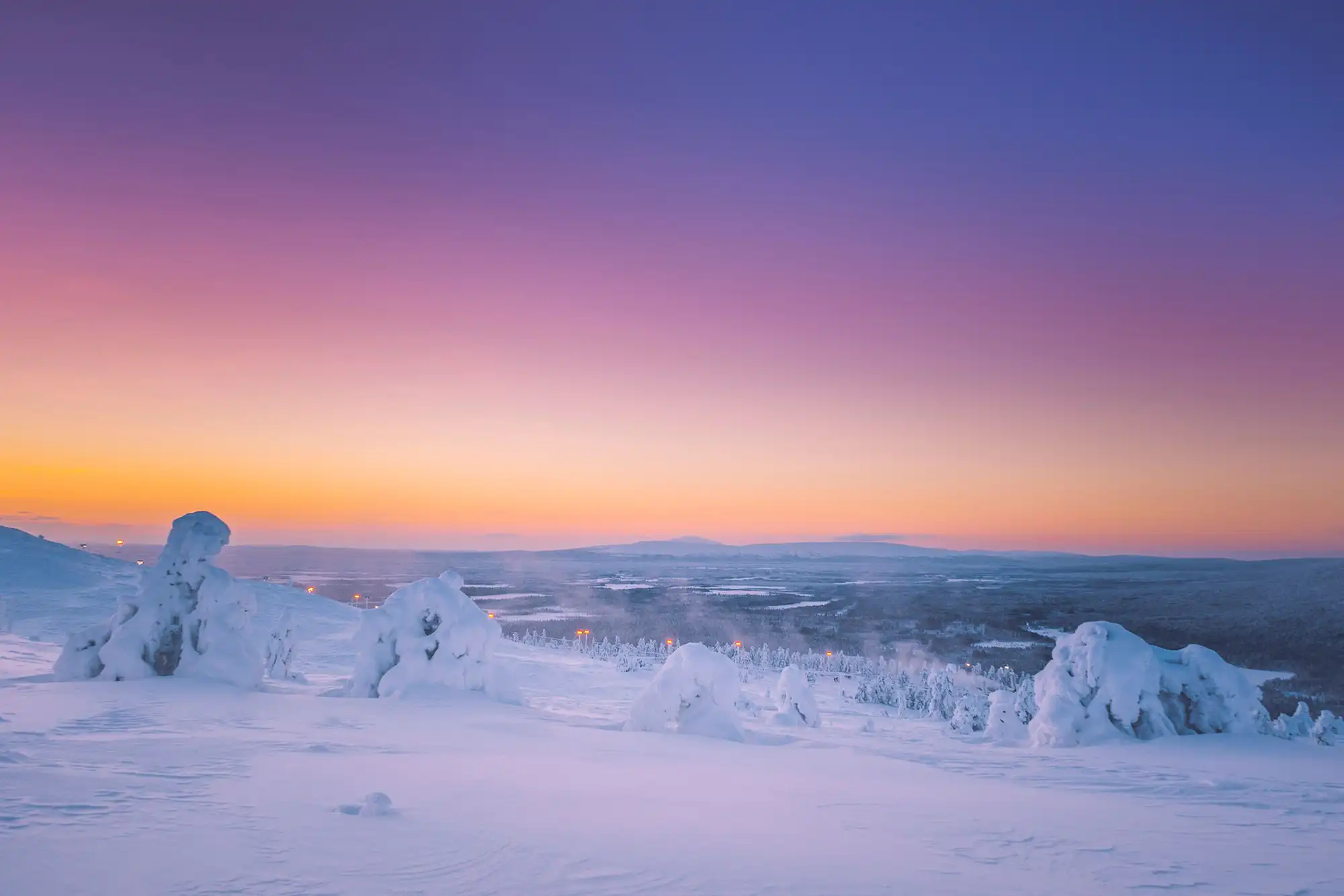 Sonnenuntergang über schneebedeckter Landschaft in Finnisch-Lappland 