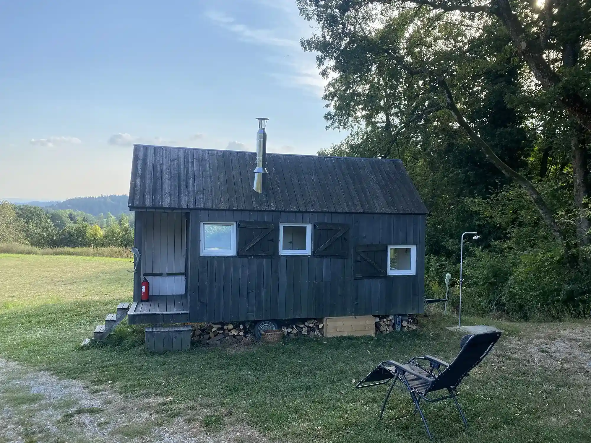 Mobiles Scheunenhäuschen unter Bäumen im Bayrischen Wald.