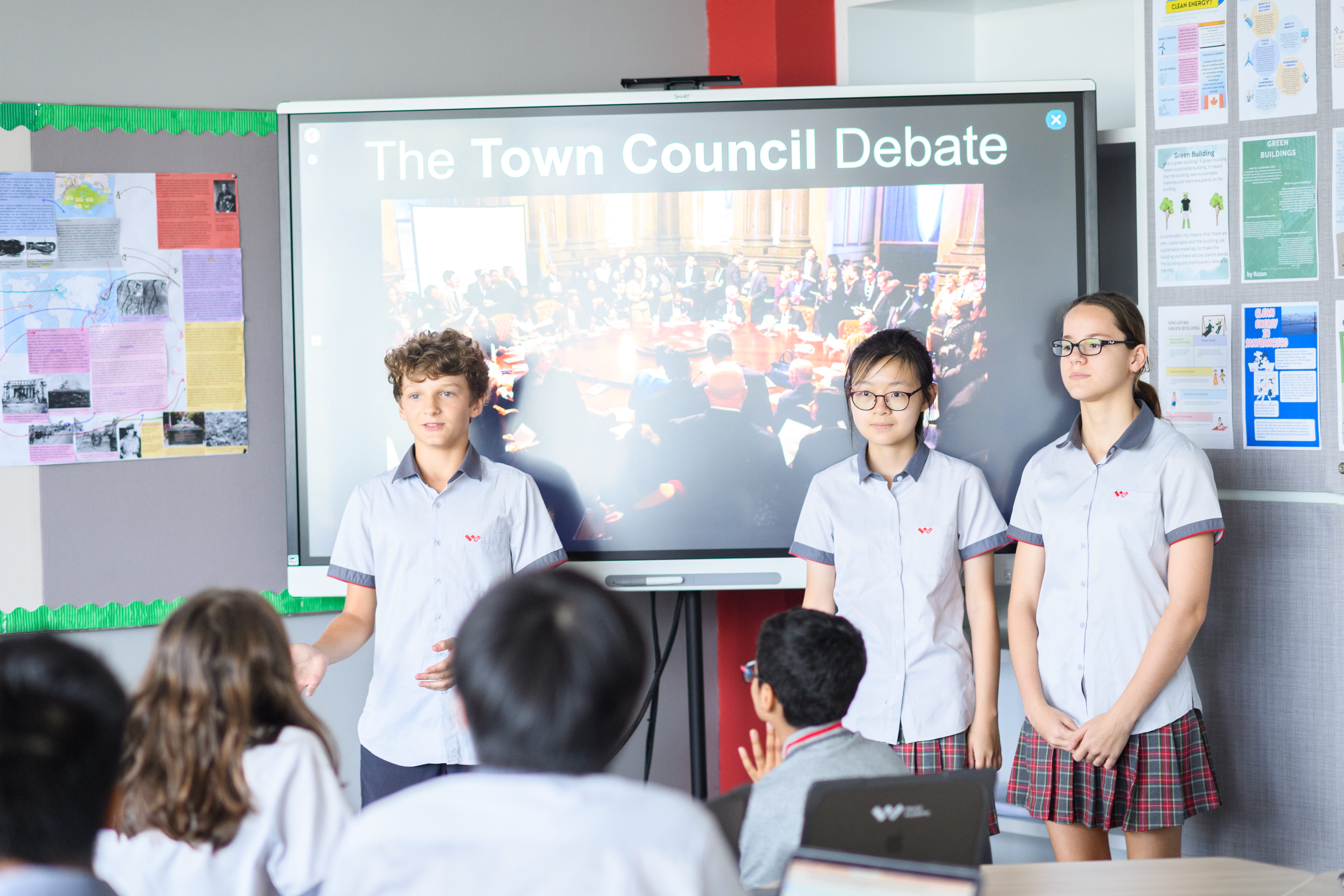 Students presenting 'The Town Council Debate' on a smartboard