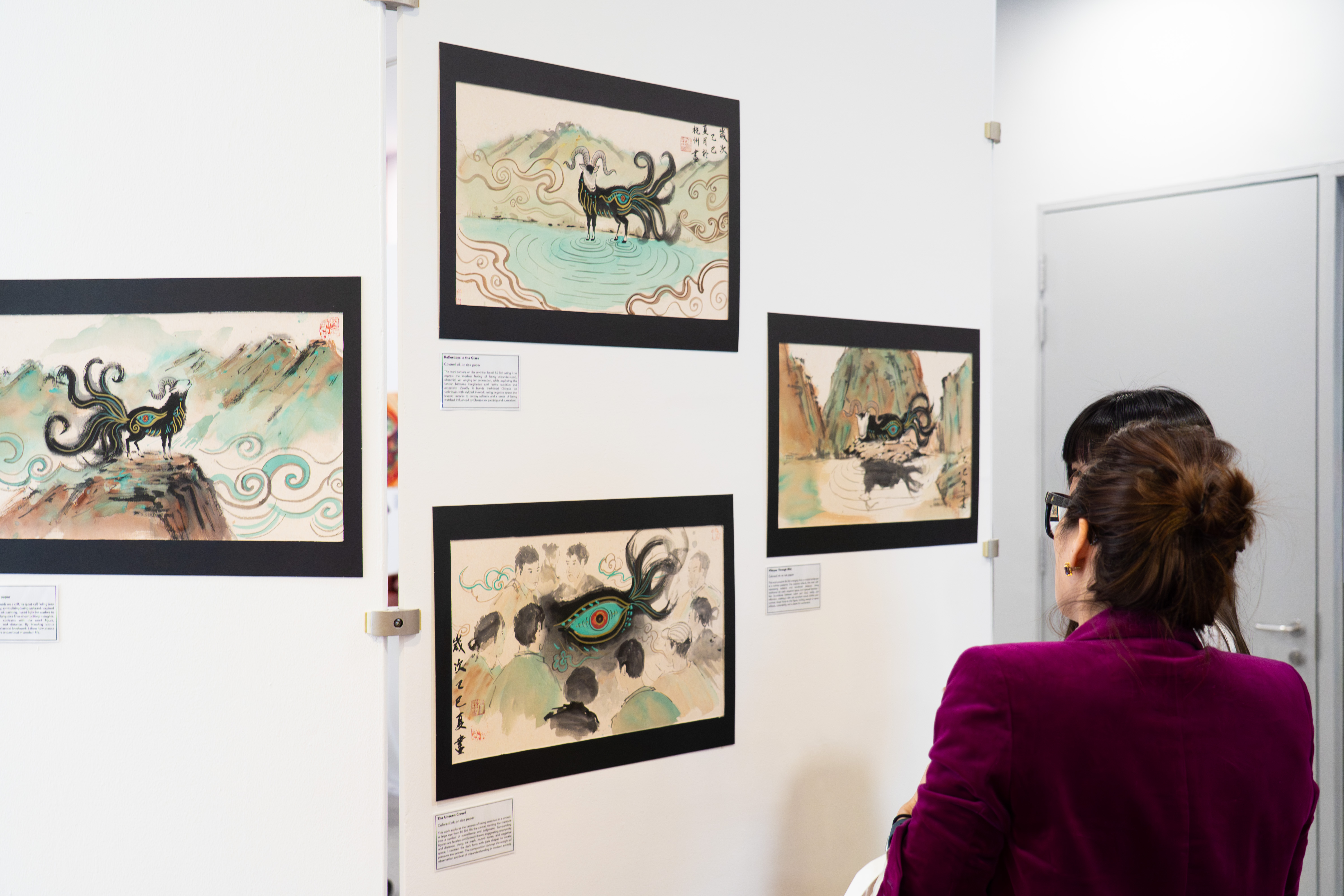 A visitor viewing Chinese ink paintings at the arts showcase