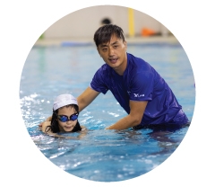 A swimming instructor teaching a child in the pool