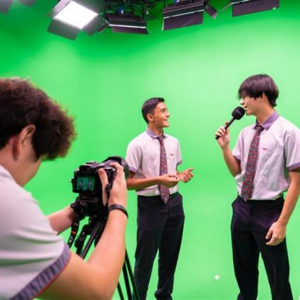 Students recording in a green-screen media studio