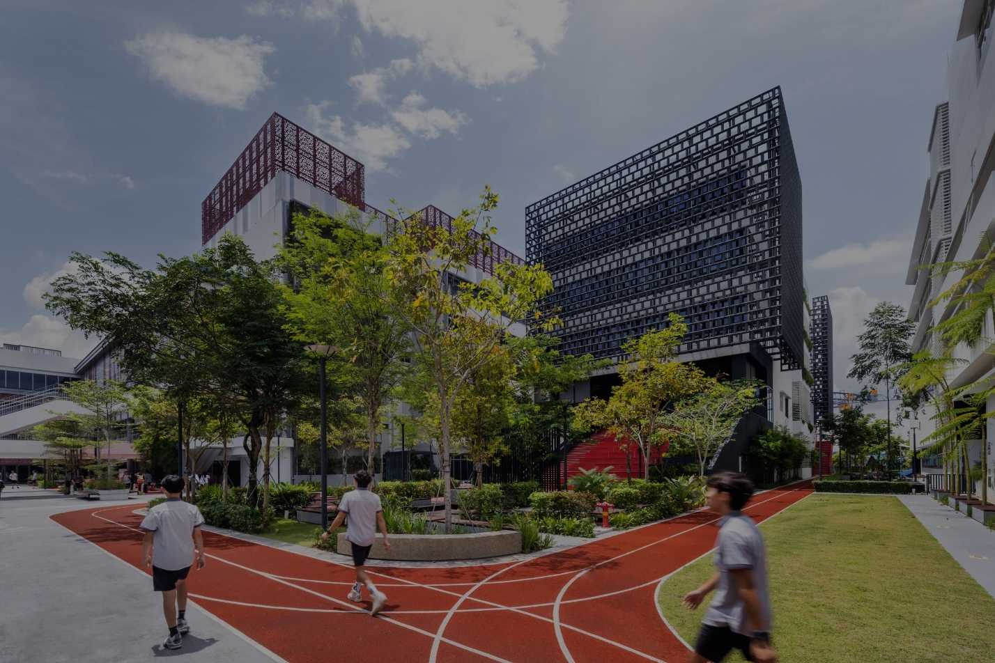 Students walking and running on the campus track beside the patterned academic building