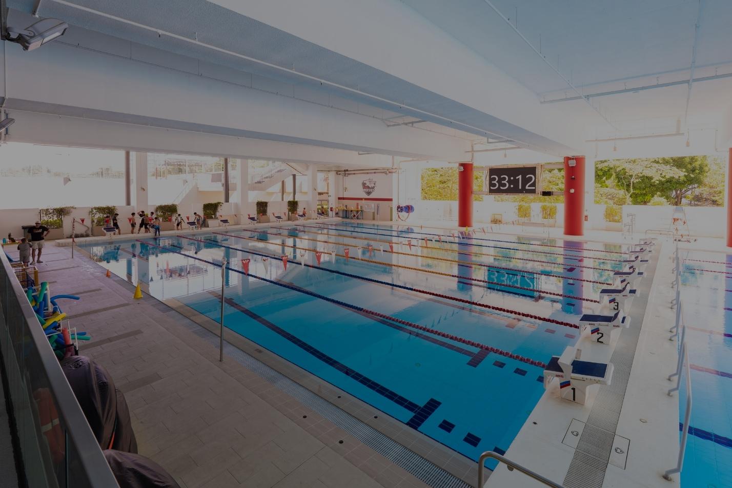 Indoor competition swimming pool with lane markers and a timing clock