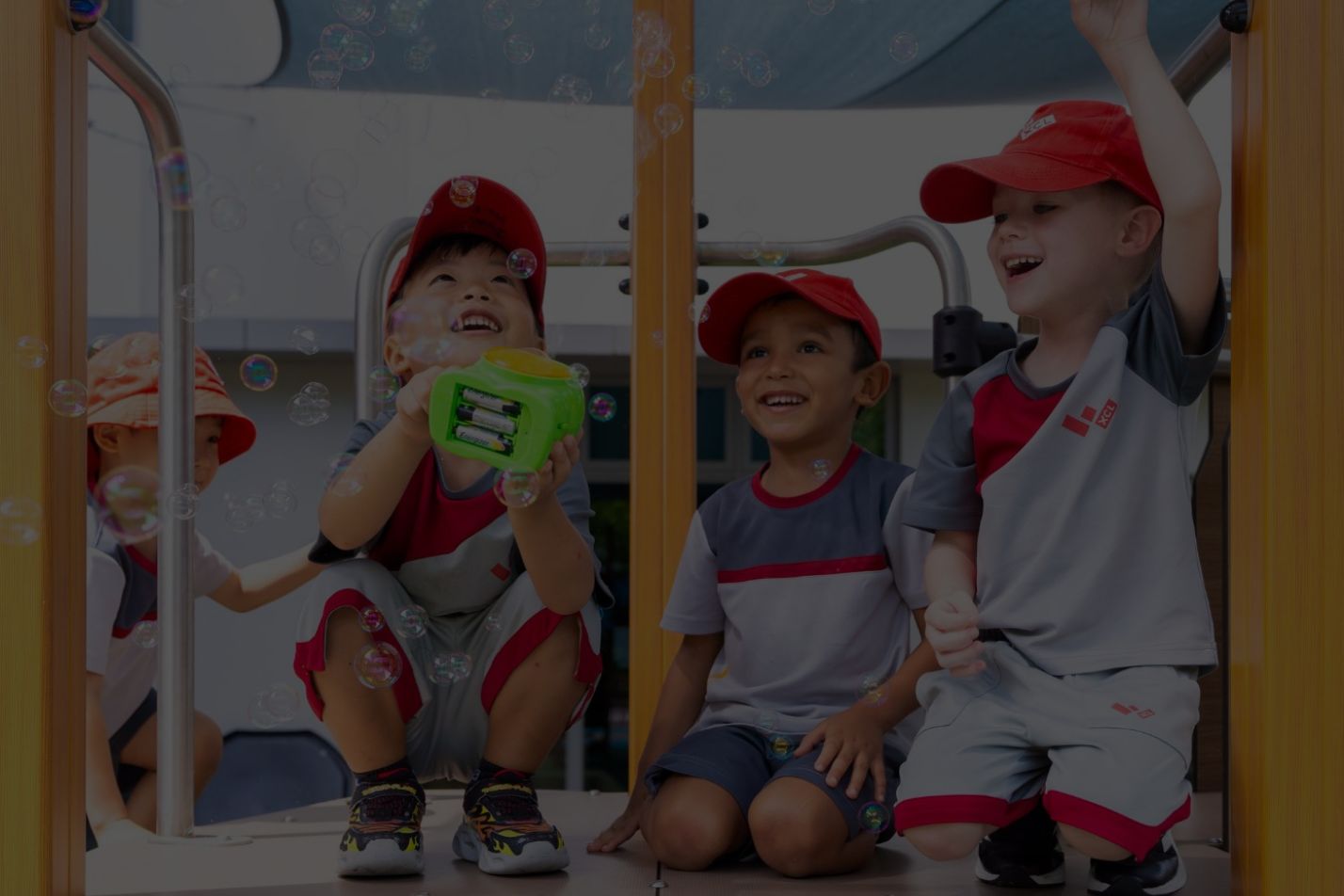 Young children playing with bubbles on a playground structure