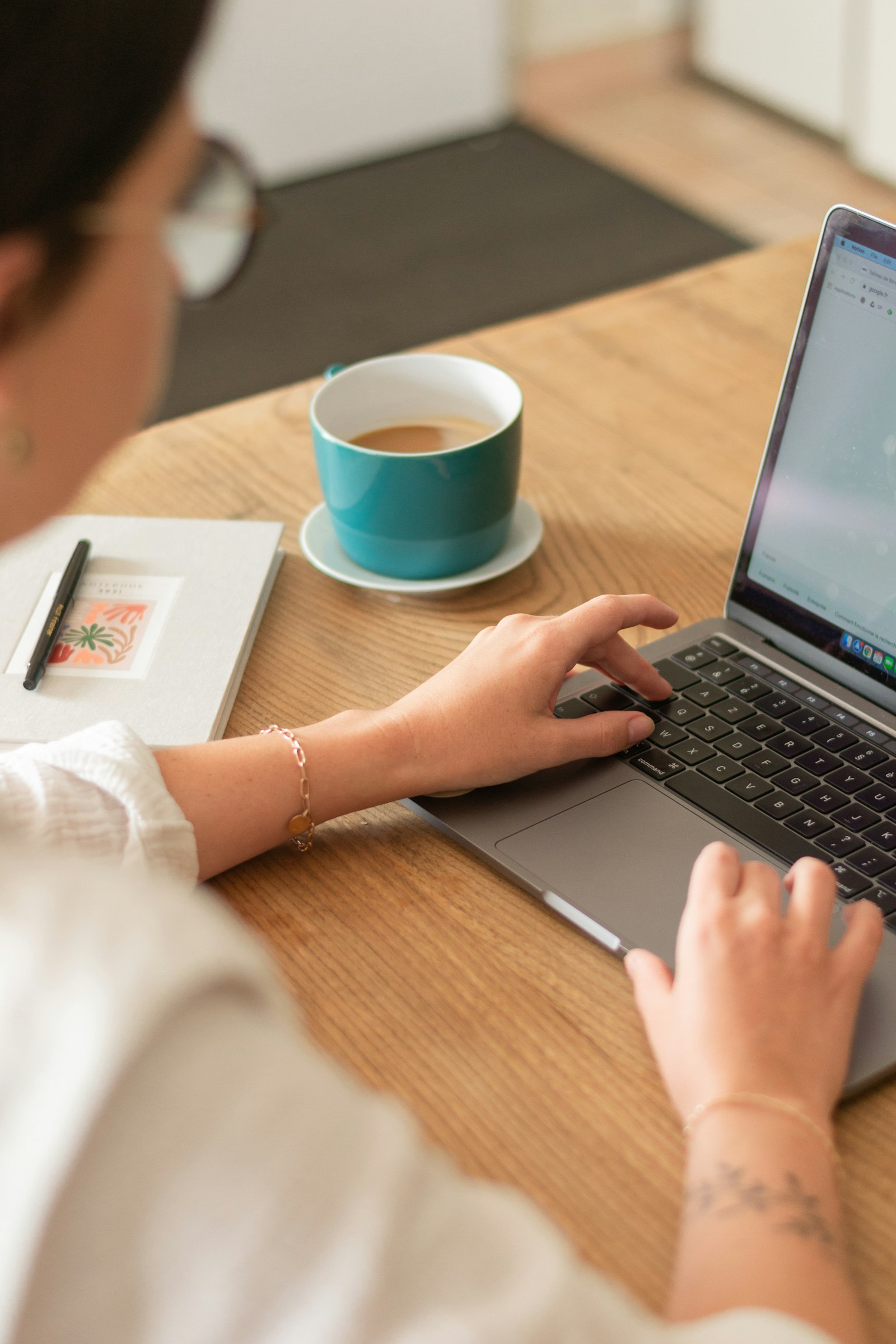 Freelancer arbeitet mit Laptop an einem Holztisch als Sinnbild für ortsunabhängiges Arbeiten im Ausland