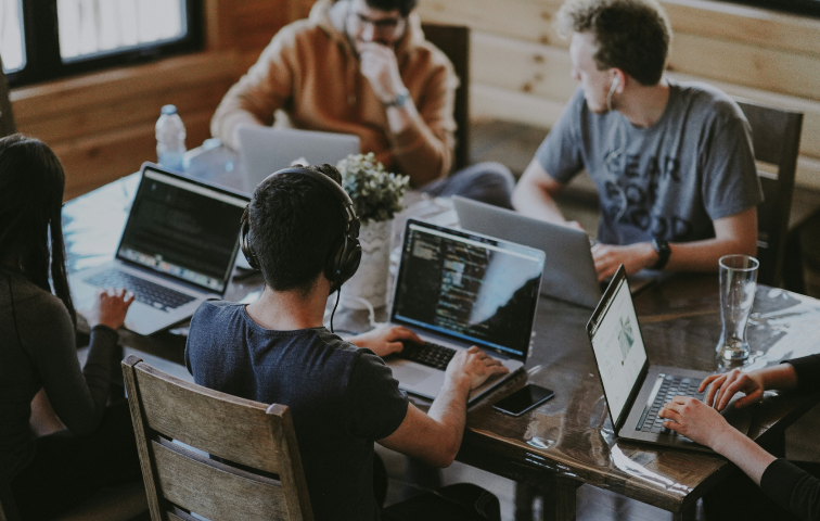 Ein Büro mit Schreibtischen, an denen Mitarbeitende arbeiten