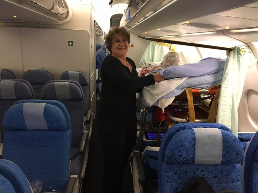 A woman is holding a baby in a plane.