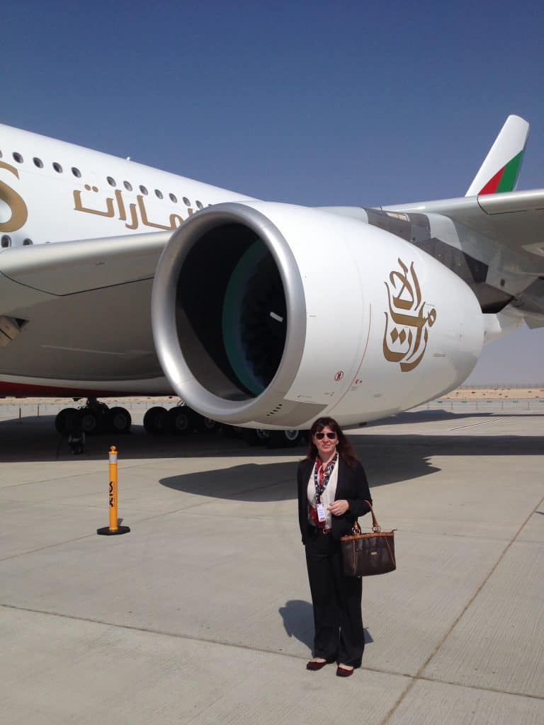 A woman standing in front of a large jet engine.