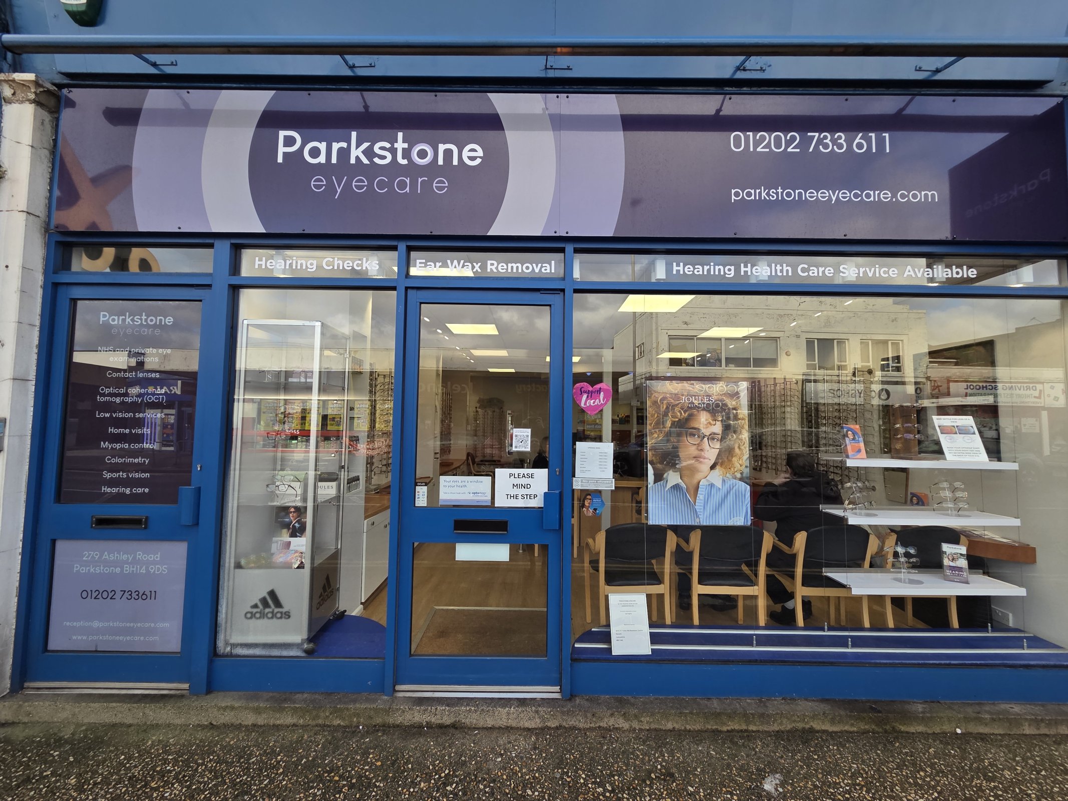 Man Trying On New Glasses At Local Opticians