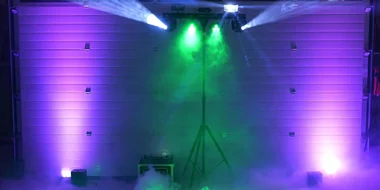 Lichtstativ mit Effektscheinwerfern in Grün und Violett über Bodennebel