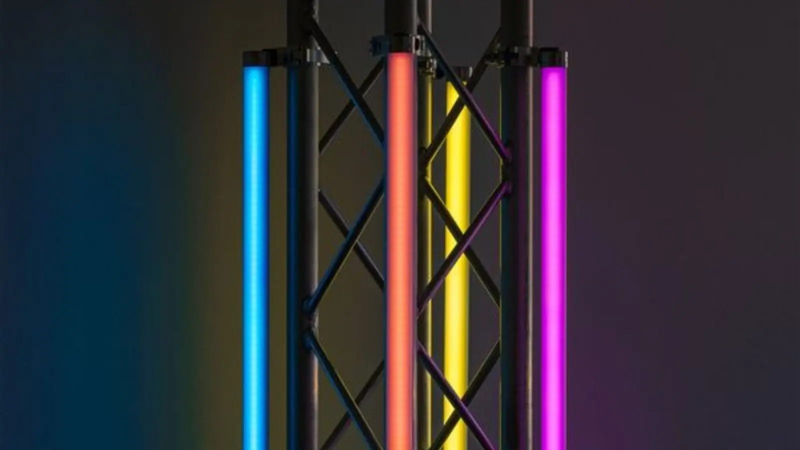 Drei ApeLabs Neon Tube Pix LED-Neonröhren in Blau, Orange und Magenta an einem Traversenständer.