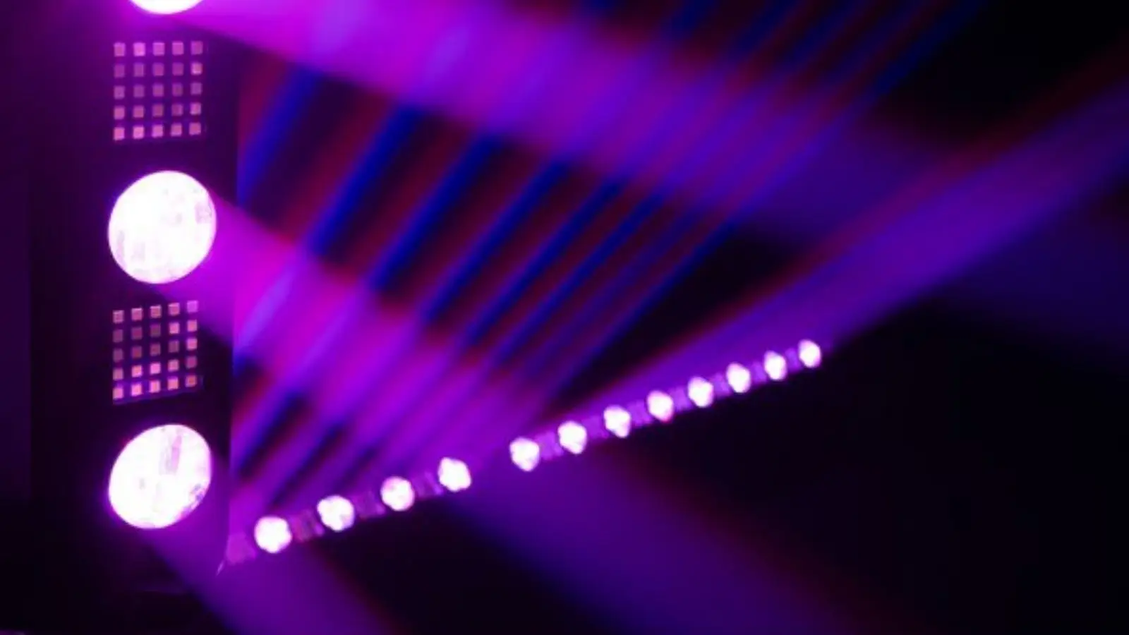 Eurolite LED BAR-8 Swing QCL Bar im Einsatz mit gefächerten violetten Lichtstrahlen auf der Tanzfläche.