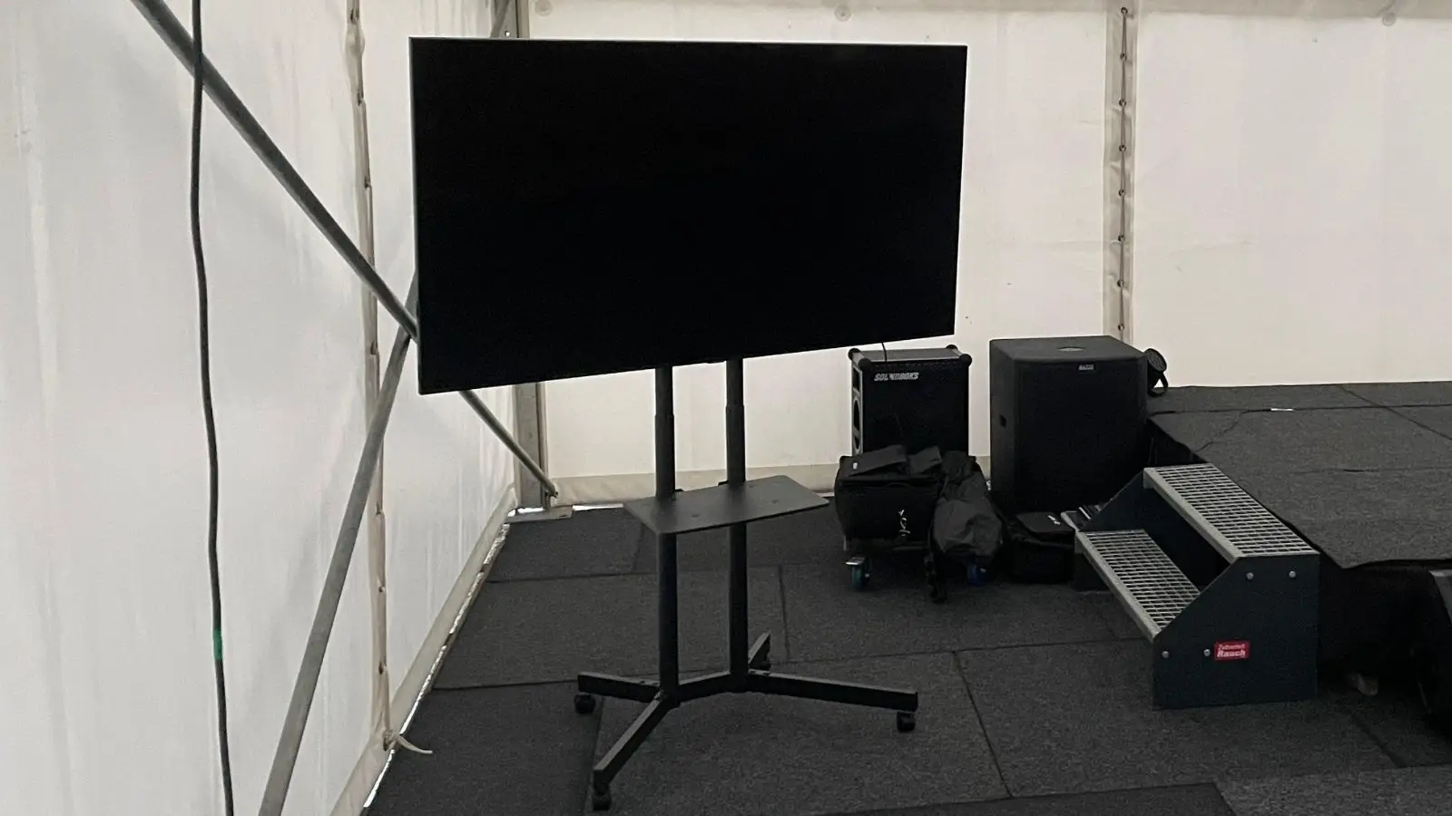 Medion 50 Zoll Fernseher auf Rollstativ in einem Eventzelt neben weiterer Veranstaltungstechnik.