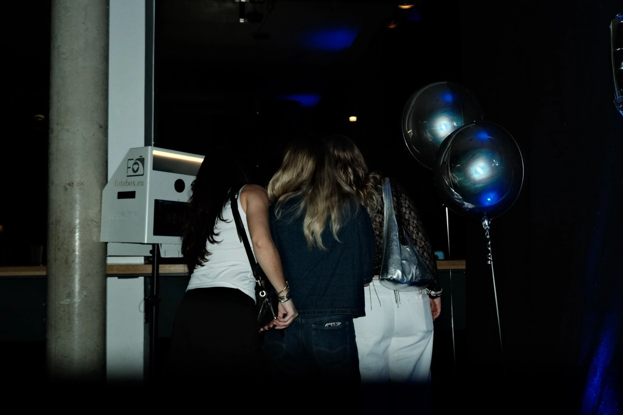 Zwei Gäste an einer Fotobox mit Luftballons bei einer Abendparty, Veranstaltungstechnik mieten in Graz.