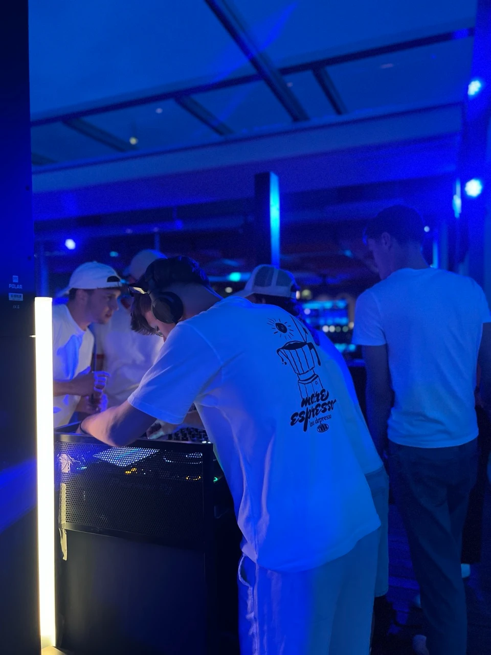 DJ am Pult mit Kopfhörern im blau beleuchteten Raum als Musikanlage mieten in St. Pölten.
