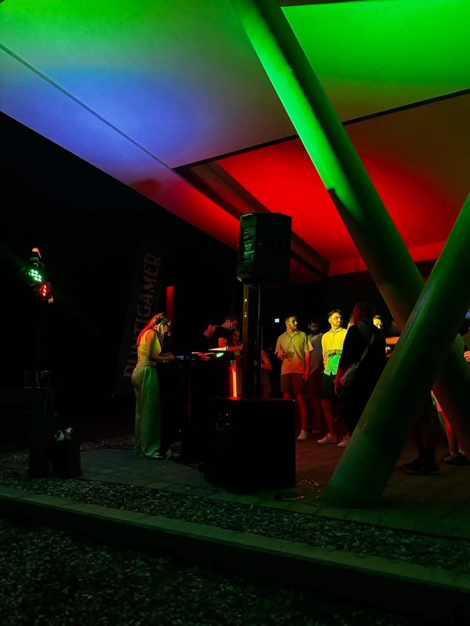 DJ-Pult mit Lautsprecher unter bunten Lichtern bei einer Gartenparty am Abend als Musikanlage mieten in Linz.