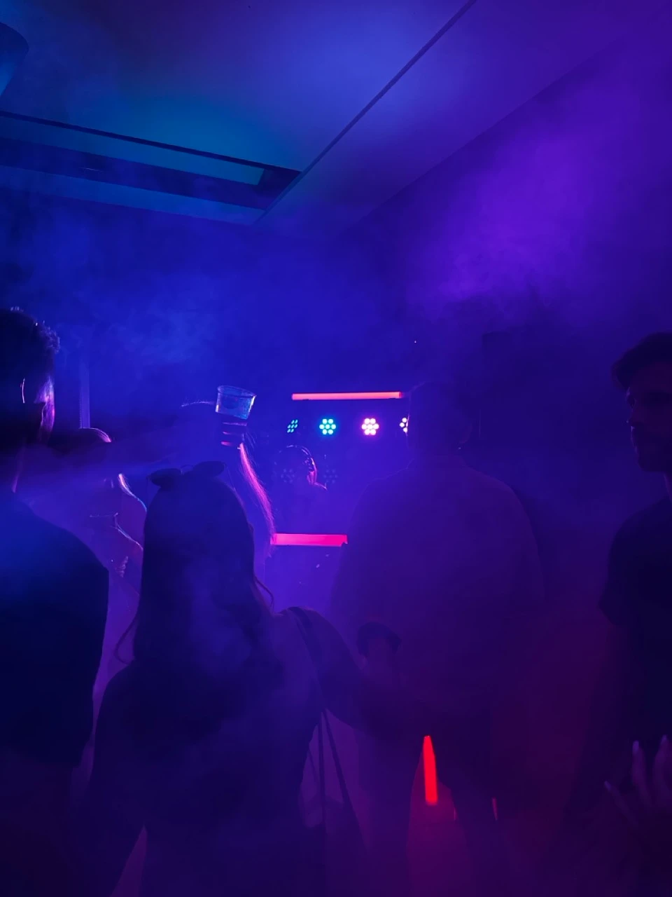 Partygäste im blauen Nebel vor LED-Strahlern und einer Lichtleiste zu Veranstaltungstechnik mieten in Linz.