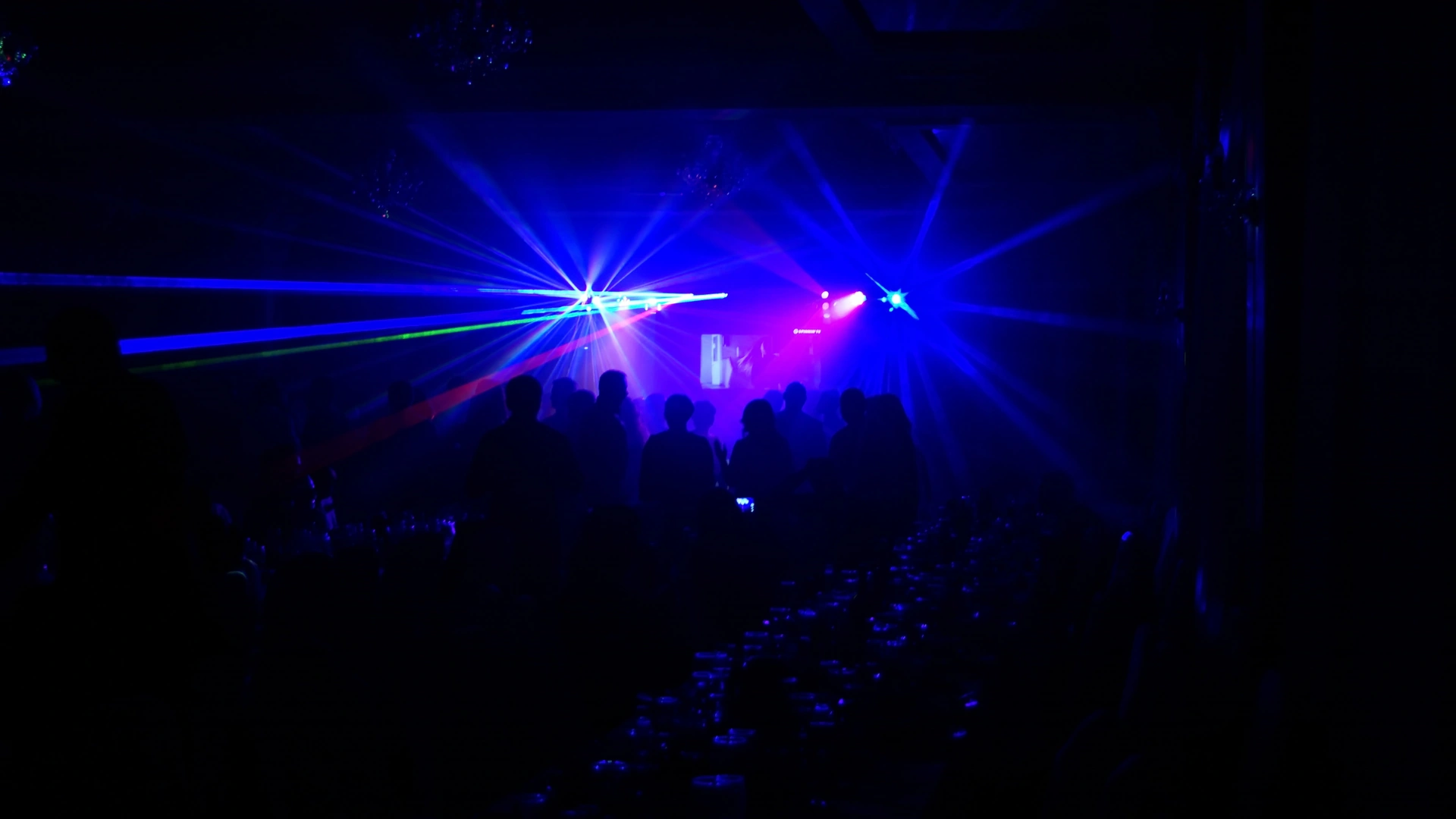 Dunkle Partylocation mit blauen und grünen Lichteffekten über der Menge für Veranstaltungstechnik mieten in Dresden.