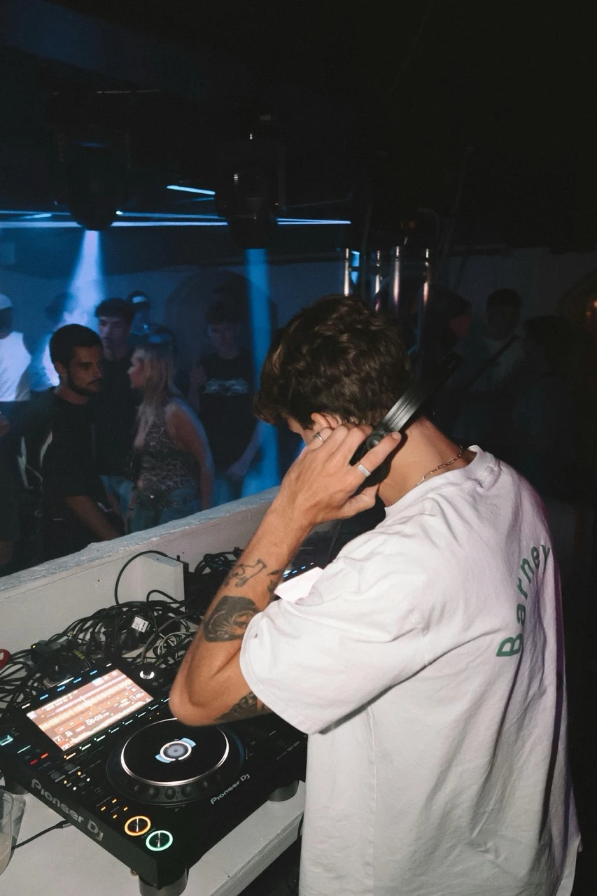 DJ mit Kopfhörern am Pioneer Pult in dunkler Location für Musikanlage mieten in Dresden.