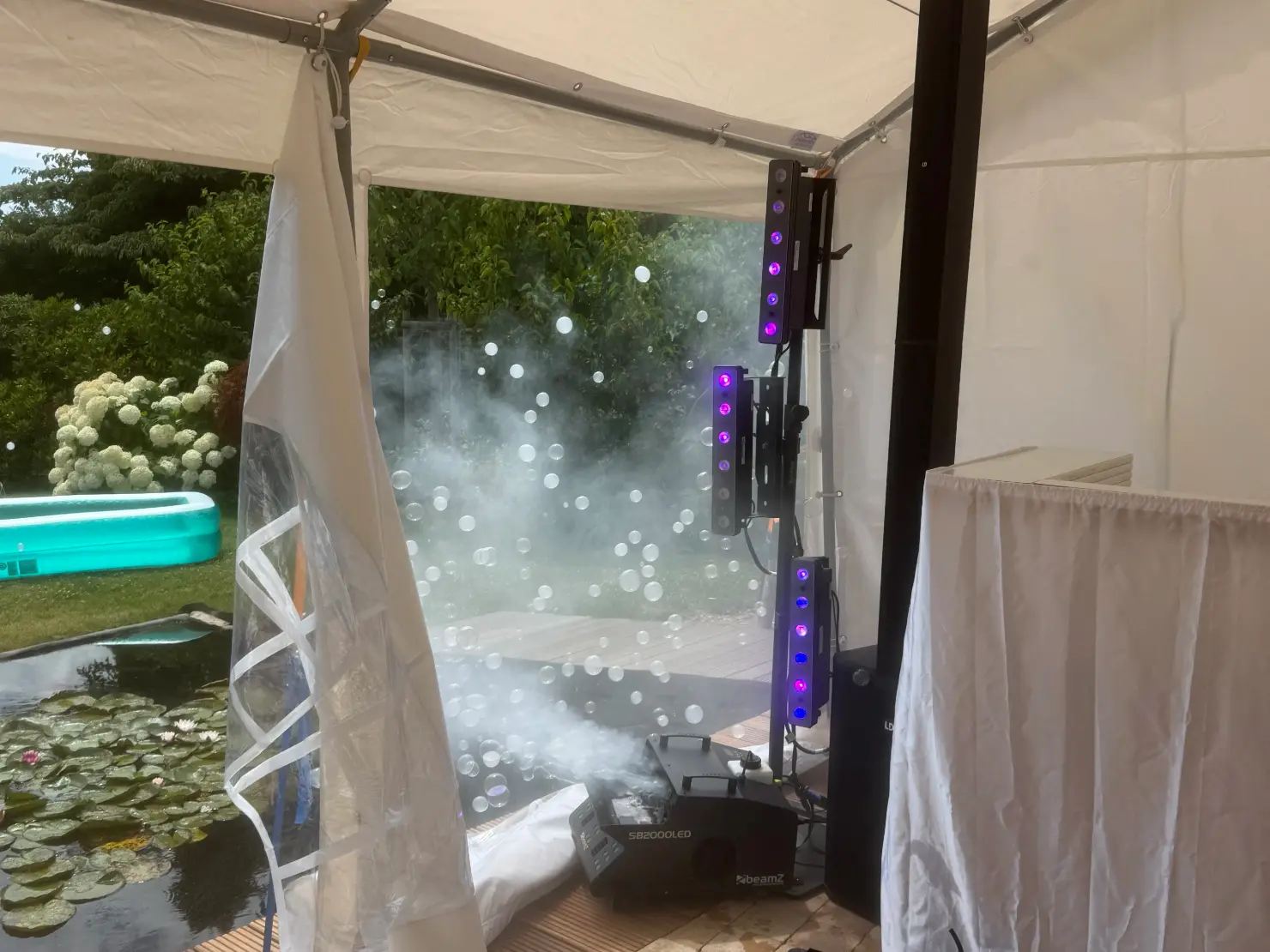 Partyzelt im Garten mit Nebelmaschine und violetten Effektlichtern für Veranstaltungstechnik mieten in Essen.